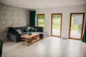 a living room with a couch and a coffee table at Dom na Zadzielu - domek z balią nad Jeziorem Żywieckim in Żywiec