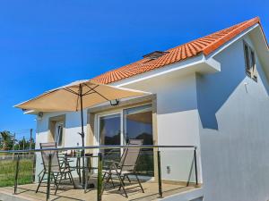 ein Haus mit Stühlen und einem Sonnenschirm auf einem Balkon in der Unterkunft Casa Mar - Camariñas - Costa da Morte in A Coruña