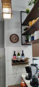 a shelf with wine glasses and a clock on a wall at THE FOUNTAINS 110 - Apartamento em lindo condomínio pé na areia da Praia das Fontes em Beberibe - CE in Beberibe