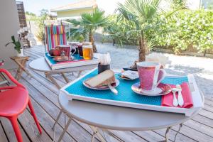 a table with a tray of food and a cup of coffee at La Maison du Cotton- Gite bio-climatique in Andernos-les-Bains