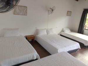Mangue的住宿－Hotel Campestre Maguey，一间客房配有两张床和一张沙发