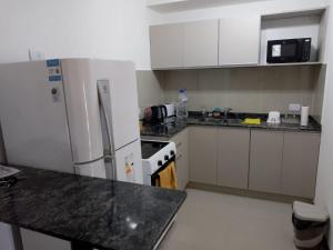 a kitchen with a white refrigerator and white cabinets at Veneto Village Departamento in Villa Parque Siquiman
