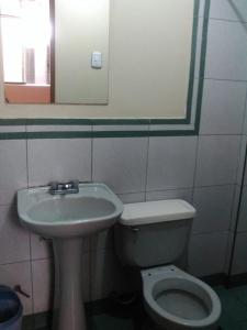 a bathroom with a sink and a toilet and a mirror at Hostal Jara in Lima