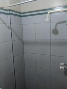 a shower with a glass door with a shower head at Hostal Jara in Lima