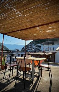 a table and chairs sitting under a wooden roof at Jemin Apartment in Berat