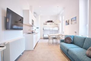 a living room with a blue couch and a kitchen at Casa Contra in La Spezia