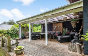 um deque de madeira com uma pérgola e mobiliário em Amazing Home In Rønde With Wifi em Rønde