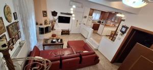 a living room with a red couch and a kitchen at Eleochori View Sea in Elaiokhórion