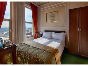 ein kleines Schlafzimmer mit einem Bett und einem Fenster in der Unterkunft Anemon Koleksiyon Galata Otel in Istanbul