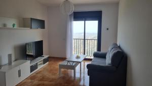 - un salon avec un canapé et une télévision dans l'établissement Apartamento Comares, à Comares