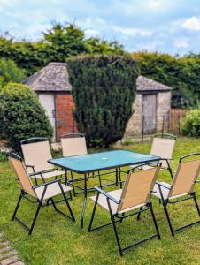 a group of chairs around a table in the grass at School View Cottage in North Cerney