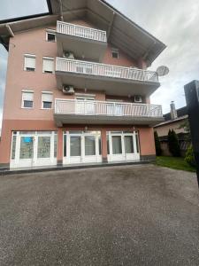 a large pink building with a balcony on the side at Vila Mariam&Maid in Sarajevo