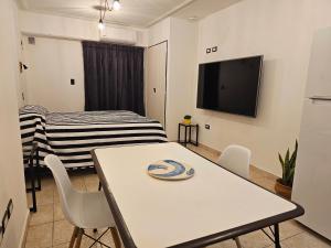 een woonkamer met een tafel en een tv bij Monoambiente moderno e inteligente en B Sur Cochera Precio en USD in San Miguel de Tucumán