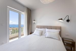 een slaapkamer met een groot bed met een groot raam bij Olive apartment in Kaštela