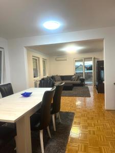 a dining room and living room with a table and chairs at Vila Mariam&Maid in Sarajevo
