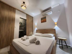 a bedroom with a white bed with towels on it at Hyka Stone House Shkoder in Shkodër +141 photos