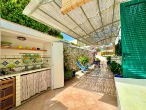 an outdoor kitchen with an umbrella on a patio at PonzaSmeralda Le Forna in Ponza