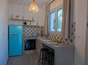 a kitchen with a blue refrigerator and a sink at Rhodes Soul luxury suites in Afantou
