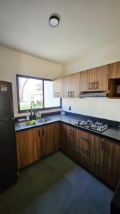 a kitchen with wooden cabinets and a black refrigerator at for in Puerto Vallarta +45 photos
