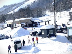 a group of people in the snow on a ski slope at 白馬パウダーマウンテン in Hakuba