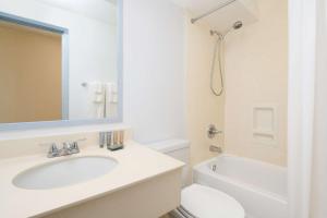 bagno con lavandino, servizi igienici e specchio di Ewa Hotel Waikiki a Honolulu