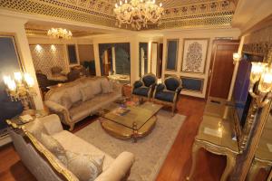 a living room with a couch and chairs and a chandelier at Radisson Blu Udaipur Palace Resort & Spa in Udaipur