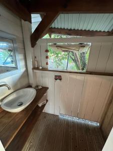 a small bathroom with a sink and a window at Rêve de Cabane in Capesterre-de-Marie-Galante
