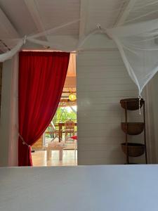 a red curtain in a room with a table at Rêve de Cabane in Capesterre-de-Marie-Galante