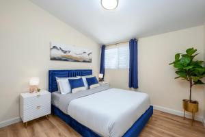 una camera da letto con un letto e una pianta in vaso di Cozy 4 Bedroom Near to Disney, Arcade and Games! a Fullerton
