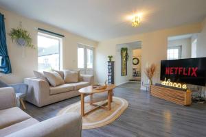 a living room with a couch and a tv at Orchard Bungalow - Sleeps 10 - Close to Town Centre - Free Parking, Pool Table, Fast Wi-Fi and Smart TV with Netflix by Yoko Property in Northampton