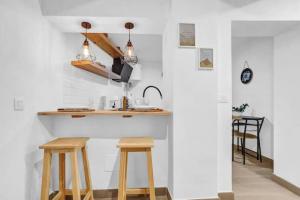 a kitchen with wooden stools and a counter with a sink at Casa Los Holandeses in Buenavista del Norte