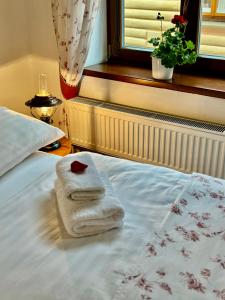 a pair of towels on a bed in a bedroom at Penzion Pohádka in Třeboň