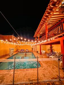 a swimming pool at night with lights around it at APARTAMENTO CÉNTRICO con PISCINA a UNA CUADRA in Santa Fe de Antioquia