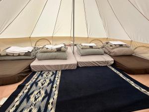 um grupo de três camas numa tenda em 森と湖の楽園ＷorkshopＣampＲesort em Fujikawaguchiko