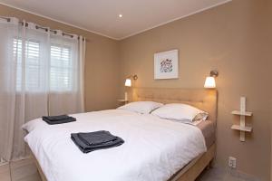 a bedroom with a large white bed with towels on it at Family-friendly apartments with swimming pool Vinisce, Trogir - 22873 in Vinišće