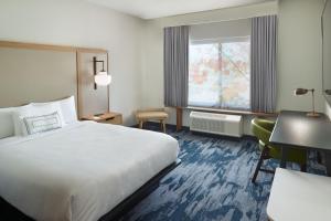 a hotel room with a bed and a desk at Fairfield Inn & Suites Locust Grove I-75 South in Locust Grove +6 photos