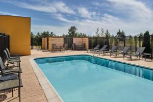 a swimming pool with chairs and a patio at Fairfield Inn & Suites Locust Grove I-75 South in Locust Grove