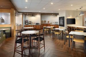 a restaurant with tables and chairs and a counter at Fairfield Inn & Suites Locust Grove I-75 South in Locust Grove