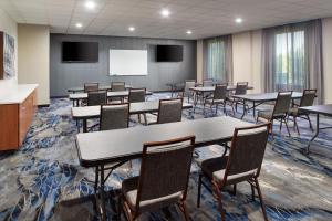a conference room with tables and chairs and a screen at Fairfield Inn & Suites Locust Grove I-75 South in Locust Grove