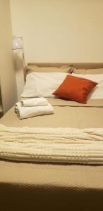 ein Bett mit zwei Handtüchern und einem roten Kissen darauf in der Unterkunft Studio Ben in São Paulo