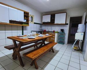 a kitchen with a wooden table and bench in it at GRA325|Refúgio Espaçoso c/ Piscina e Churrasqueira in Gravatá