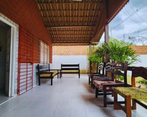 a group of benches sitting on a porch at GRA325|Refúgio Espaçoso c/ Piscina e Churrasqueira in Gravatá
