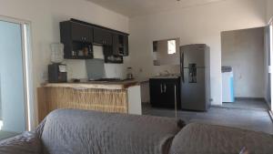 a kitchen with a couch and a kitchen with a refrigerator at Casa brisas del mar in Ipala