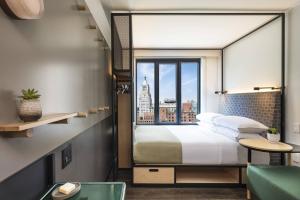 a bedroom with a bed with a view of the city at Moxy NYC East Village in New York