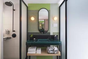 ニューヨークにあるMoxy NYC East Villageのバスルーム(緑のシンク、鏡付) +37枚の写真