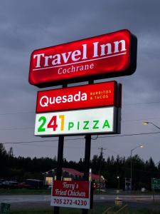 ein Schild für ein Reisegasthofrestaurant auf einer Straße in der Unterkunft Travel Inn Cochrane in Cochrane