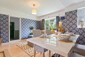 a dining room with a white table and chairs at Beautiful 5 Bedroom House in Aylesbury free Parking PENN ROAD in Buckinghamshire