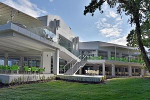 a large white building with green chairs and tables at Villas Holidays in Primorsko