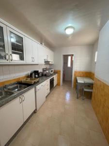 萨伊迪耶Marina Ap2的厨房配有白色橱柜、水槽和桌子