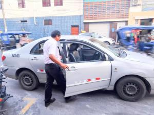 a man opening the door of a white car at Casa Nativa Iquitos in Iquitos